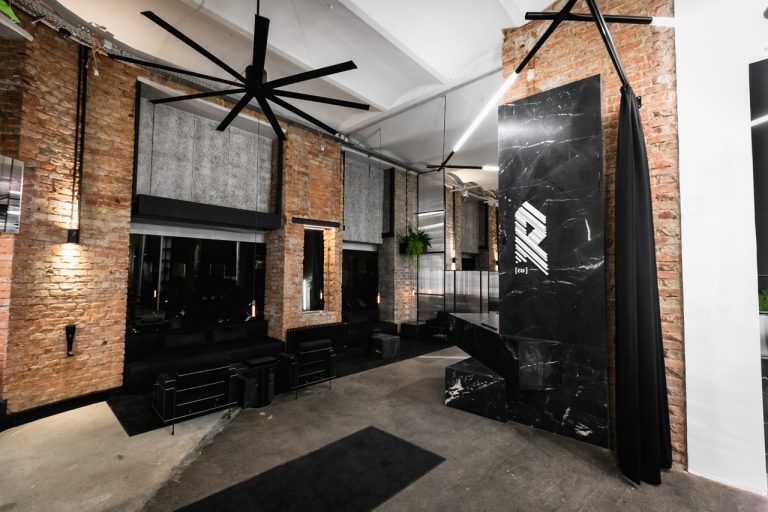 Eleganter Empfangsbereich mit dunklem Marmor und stilvoller Beleuchtung. R Tattoo x Barber Tattoostudio in Wien