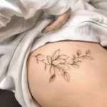 Ein florales Fine Line Blumentattoo für Frauen