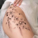 Ein florales Fine Line Blumentattoo für Frauen