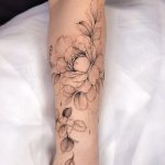 Ein florales Fine Line Blumentattoo für Frauen