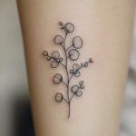 Ein florales Fine Line Blumentattoo für Frauen